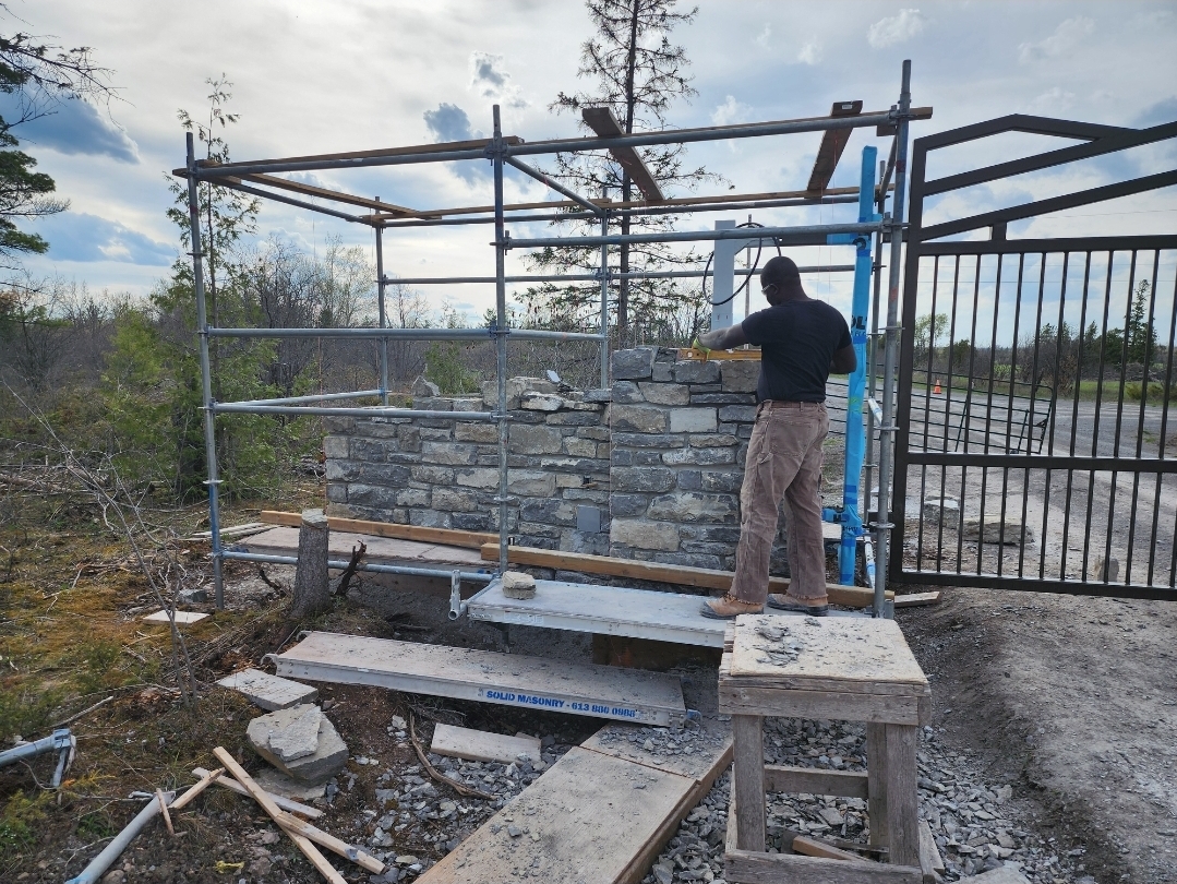 Garvin Louisy working on a custom natural-stone entrance wall